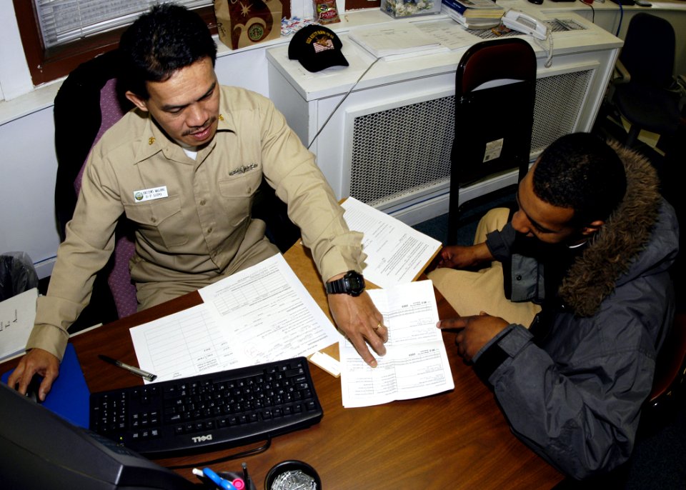 US Navy 060301-N-2385R-007 Chief Storekeeper James Malong, left, assists Quartermaster 3rd Class Andrew Johnson in the preparation of his taxes on board U.S. Fleet Activities, Yokosuka, Japan