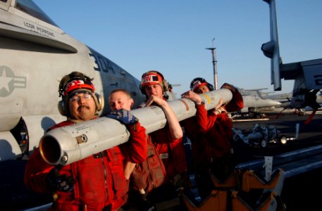 US Navy 060225-N-4776G-135 Aviation ordnancemen lift ordnance to place on an F-A-18C Hornet aboard the Nimitz-class aircraft carrier USS Ronald Reagan (CVN 76)