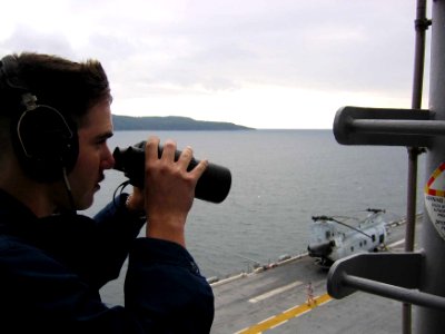 US Navy 060218-N-C4880-002 Operations Specialist 3rd Class Eddie Garcia stands watch on the signal bridge aboard the amphibious assault ship USS Essex (LHD 2)