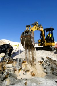 US Navy 060324-5328N-N-769 Using a mini excavator, a heavy equipment operator with the Pittsburgh, Pa.-based, Dick Corp. carefully covers the remains of a wrecked wooden ship aboard Naval Air Station Pensacola