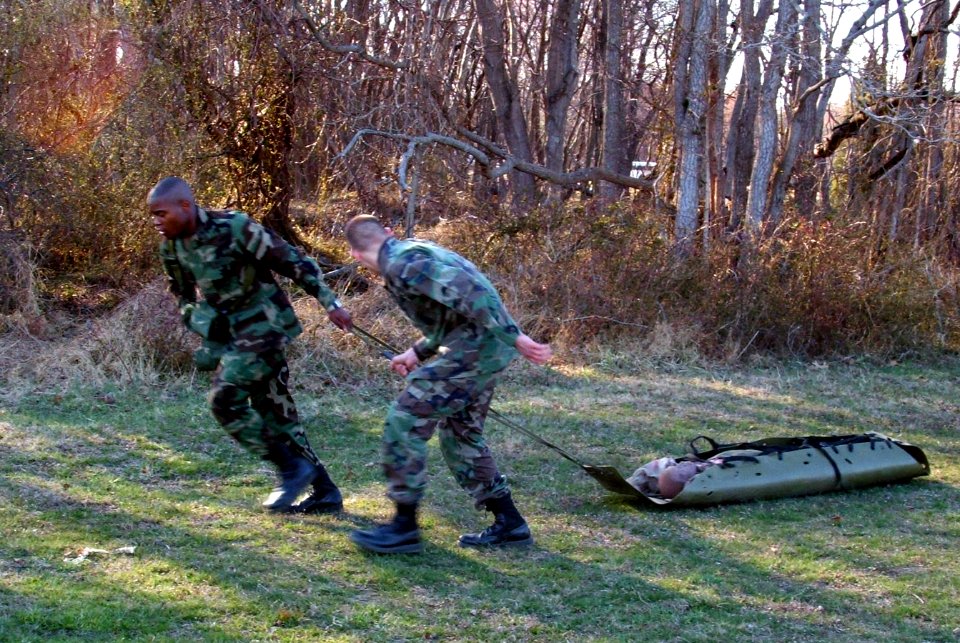 US Navy 060327-F-9429S-048 U.S. Navy Master-at-Arms 2nd Class Warren Summers and U.S. Air Force Airman 1st Class Andrew Prunitis, both students in the Air Force Phoenix Raven Class 06-D pull a simulated patient through an obsta photo