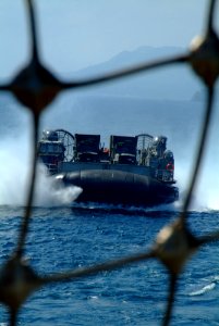 US Navy 060303-N-4772B-217 A Landing Craft, Air Cushion (LCAC) loaded with equipment from the 31st Marine Service Support Group (MSSG) makes its way toward the stern gate of the amphibious dock landing ship USS Harpers Ferry (L