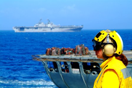 US Navy 060225-N-4772B-099 Landing Signal Enlisted (LSE), Gunner's Mate 3rd Class Nikole Povolish prepares for the next helicopter to reach the flight deck aboard the dock landing ship USS Harpers Ferry (LSD 49)