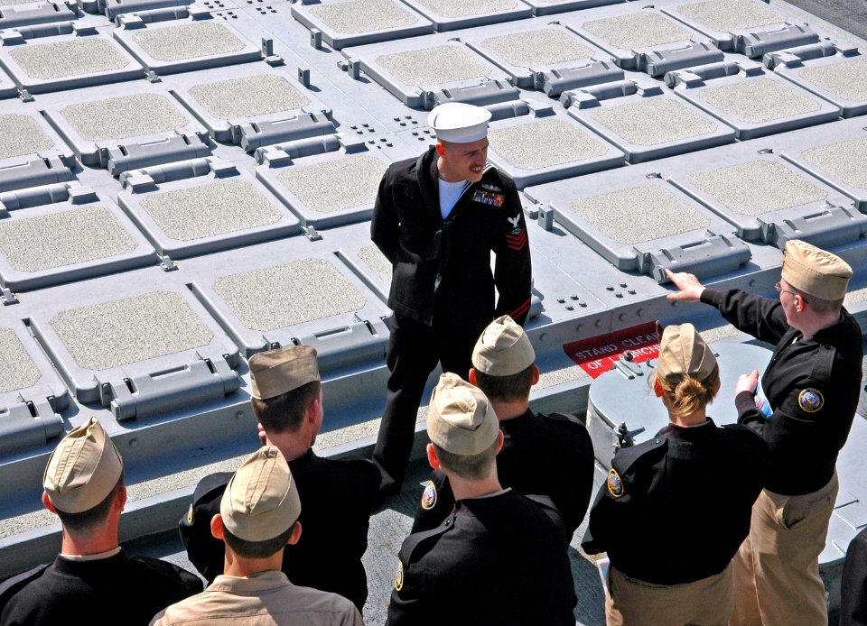 US Navy 060307-N-3532C-026 A Sailor assigned to the guided missile destroyer, USS Bunker Hill (CG 52) explains basic shipboard missile capabilities to a class of Naval Junior Reserve Officer Training Corps (NJROTC), students