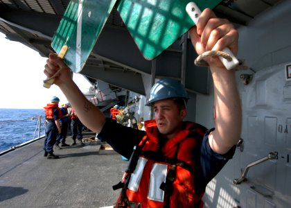US Navy 060318-N-7526R-033 Boatswain's Mate 3rd Class Ricky Winger, practices signaling aboard the amphibious command ship USS Blue Ridge (LCC 19) prior to a replenishment at sea