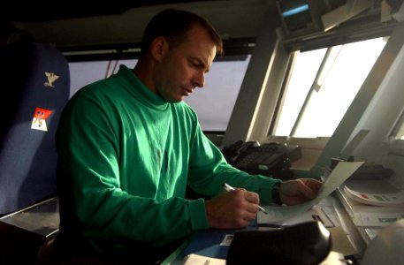 US Navy 060220-N-4776G-171 USS Ronald Reagan (CVN 76) Commanding Officer, Capt. Terry Kraft, reads through the Sailor of the Day biography and prepares for his meeting with the selected Sailor