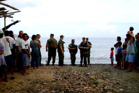 US Navy 060221-N-4772B-189 Beachmaster Unit One (BMU-1) Detachment Western Pacific members wait near the shore for a landing craft to approach and offload relief equipment from the amphibious dock landing ship USS Harpers Ferry