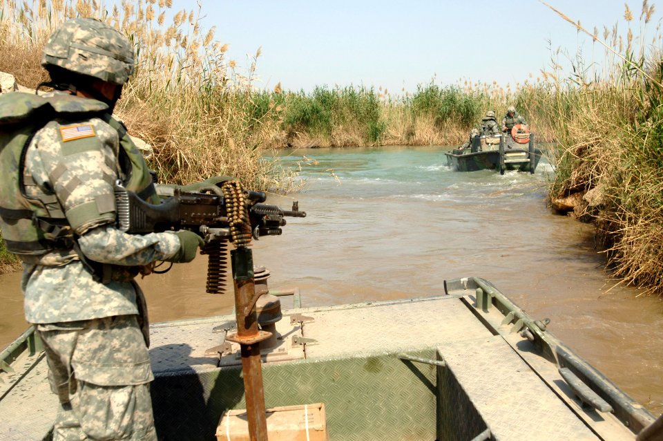 US Navy 060321-N-8252B-024 Master Sgt. Nardo Dedicatoria watches as a boat pulls out into the Euphrates River. Company E, 1st Battalion, 67th Armored Regiment performs a reconnaissance mission of the Musayyib Bridge