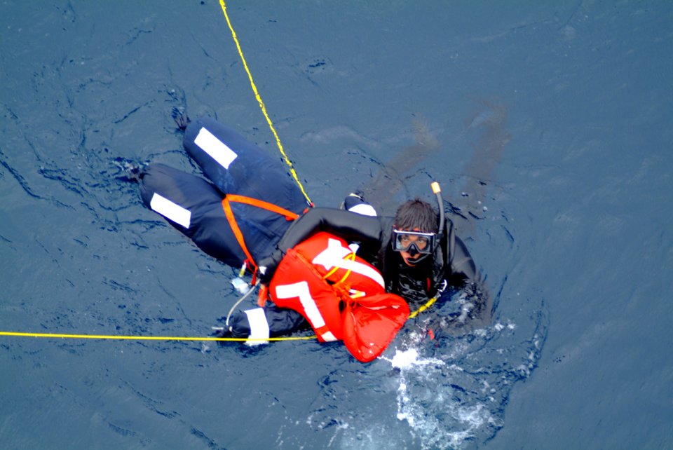 US Navy 060406-N-4772B-041 During a man overboard drill, search and rescue (SAR) swimmer, Yeoman 3rd Class Francisco J. Degollado secures the ship's training manakine