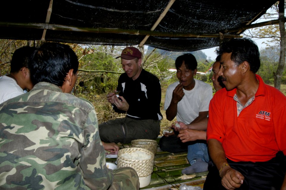 US Navy 060312-F-0365G-019 U.S. Navy Lt. Cmdr. Brian Danielson, center, enjoys lunch with Lao officials during a break at the work site in Boualapha