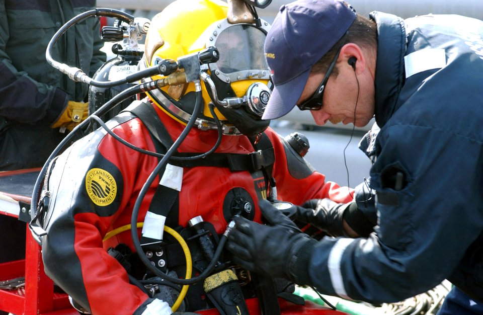 US Navy 060329-F-3759D-003 Chief Hull Technician Cliff Morin assigned to the rescue and salvage ship USS Safeguard (ARS 50) prepares a Safeguard crewmember to dive