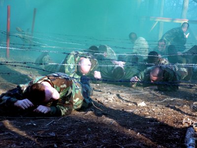 US Navy 060327-F-9429S-050 Students participating in the Air Force Phoenix Raven Class 06-D pull a simulated patient through an obstacle course during combat first aid training photo