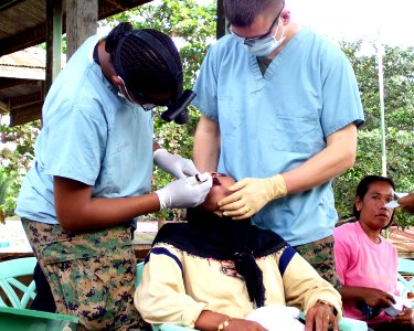 US Navy 060302-A-2948K-001 Lt. Toni Bowden, of the 31st Marine Expeditionary Unit (MEU), performs dental work on a Filipino patient in Maimbang photo