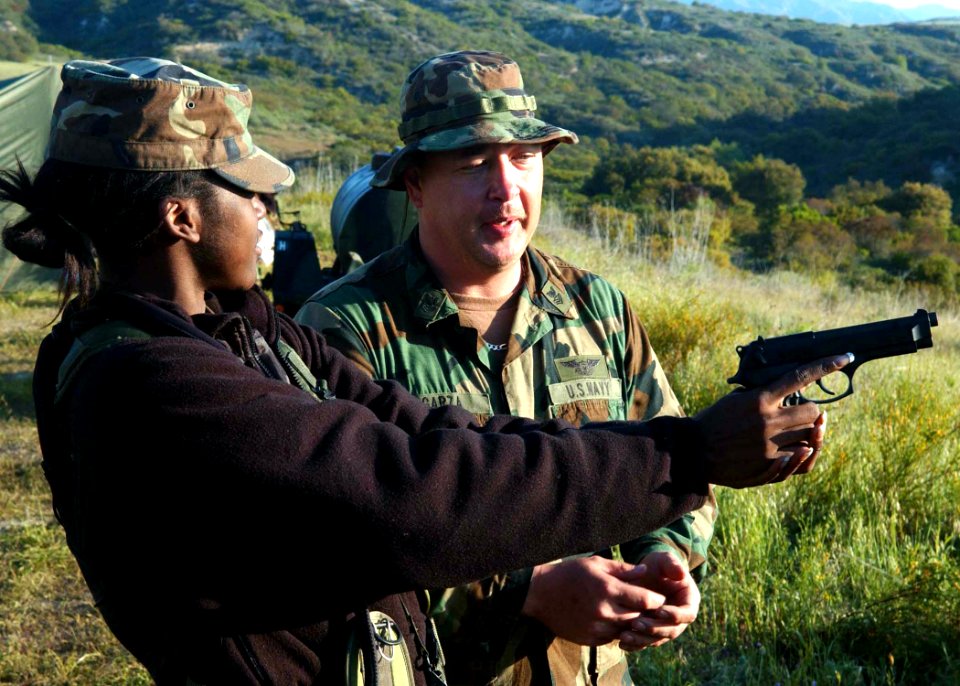 US Navy 060420-F-0692M-020 U.S. Navy Photographer's Mate 2nd Class Felix Garza assigned to Combat Camera Group Pacific, instructs U.S. Air Force Airman Corenthia Fennell