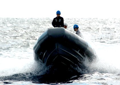 US Navy 060302-N-7359L-001 The Arleigh Burke-class guided missile destroyer USS Mason (DDG 87) Sailors transport personnel with in a rigid-hull inflatable boat (RHIB), during a replenishment at sea photo