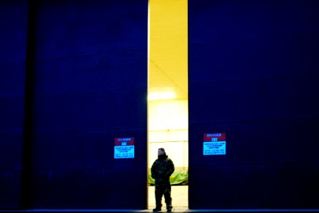 US Navy 060329-N-6074Y-022 Aviation Electronics Technician Airman Shane Pfannestiel, assigned to Helicopter Anti-Submarine Squadron Two (HS-2) Golden Falcons, stands at the door of an aircraft hangar