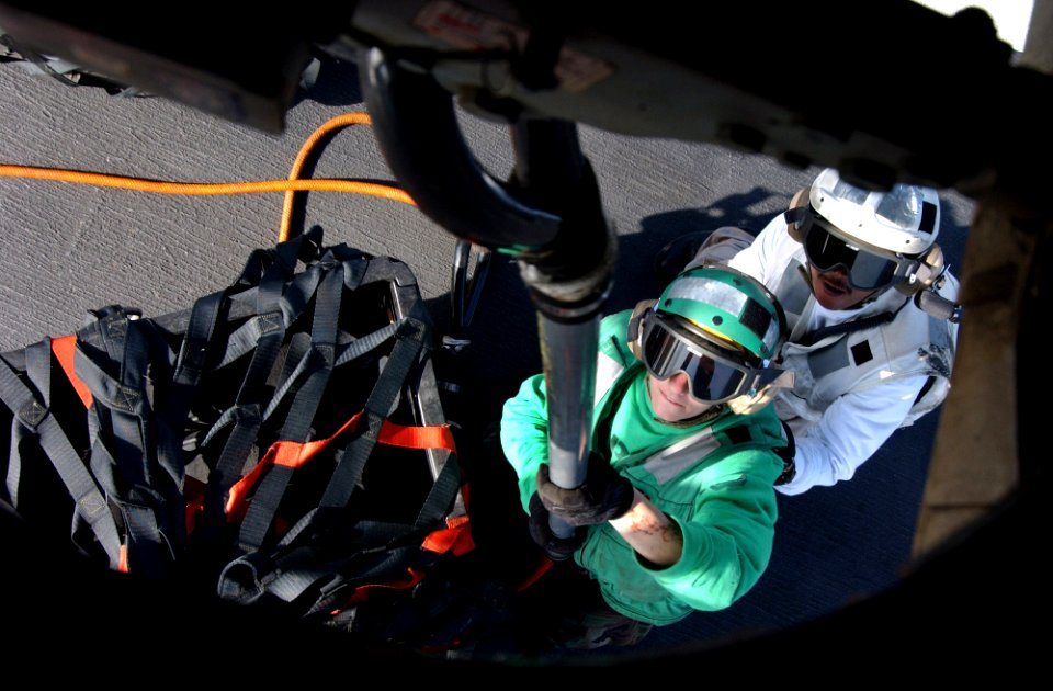 US Navy 060420-N-4776G-115 A Sailor and his spotter latches a cargo pendant to the bottom of an HH-60H Seahawk helicopter assigned to the Black Knights of Helicopter Anti-Submarine Squadron Four (HS-4) during a stimulated verti