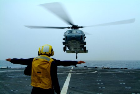 US Navy 060410-N-4772B-080 Landing Signal Enlisted (LSE) Boatswain's Mate Seaman Michael Fifer launches an MH-60S Seahawk helicopter