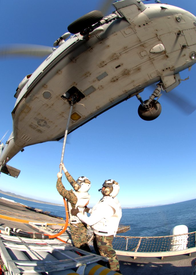 US Navy 060411-N-0716S-032 Staff Sgt. Nathaneal Hart attaches a cargo pendant to an MH-60S Seahawk helicopter,