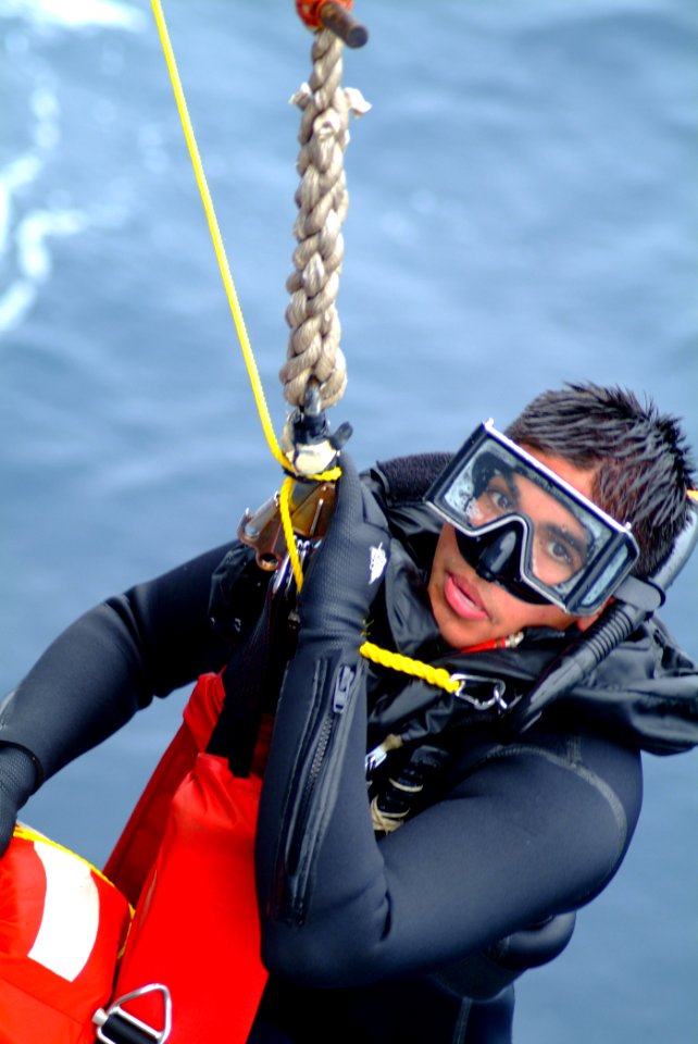 US Navy 060406-N-4772B-059 Search and rescue (SAR) swimmer, Yeoman 3rd Class Francisco J. Degollado is hauled aboard the amphibious dock landing ship USS Harpers Ferry (LSD 49) during a man overboard drill