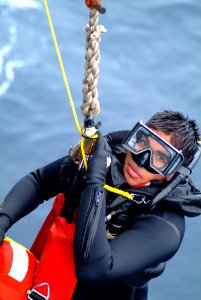 US Navy 060406-N-4772B-059 Search and rescue (SAR) swimmer, Yeoman 3rd Class Francisco J. Degollado is hauled aboard the amphibious dock landing ship USS Harpers Ferry (LSD 49) during a man overboard drill