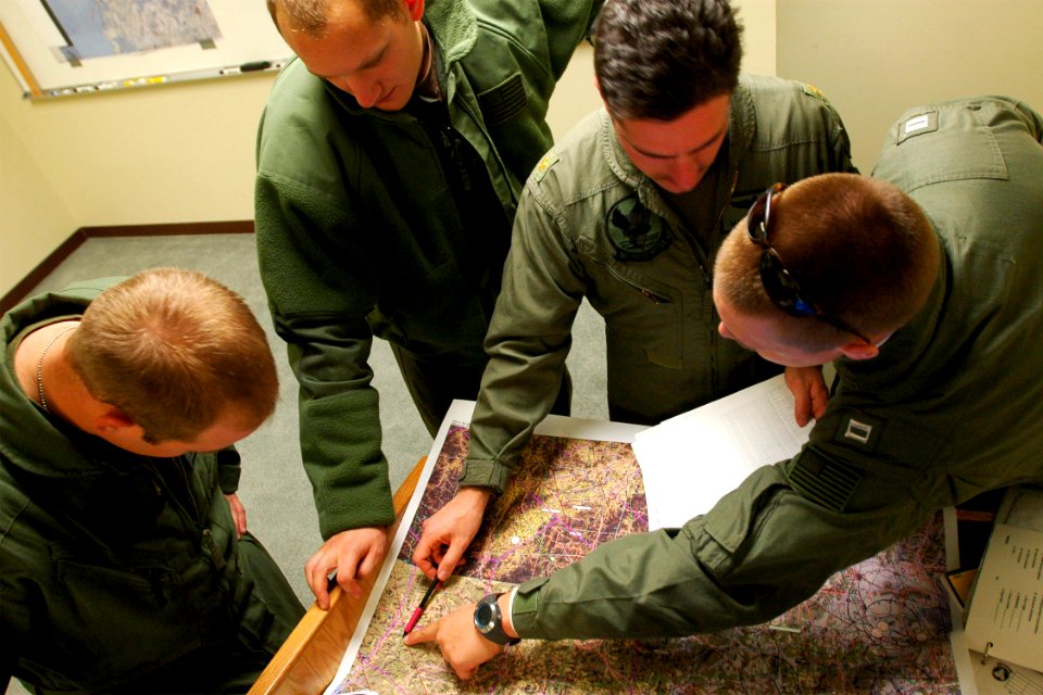 US Navy 060328-N-6074Y-048 Lt. Greg C. Knutson, a pilot from Helicopter Anti-Submarine Squadron Two (HS-2) Golden Falcons, reviews flight details on an operational map with Lt. Cmdr. Mark Leavitt and air crew