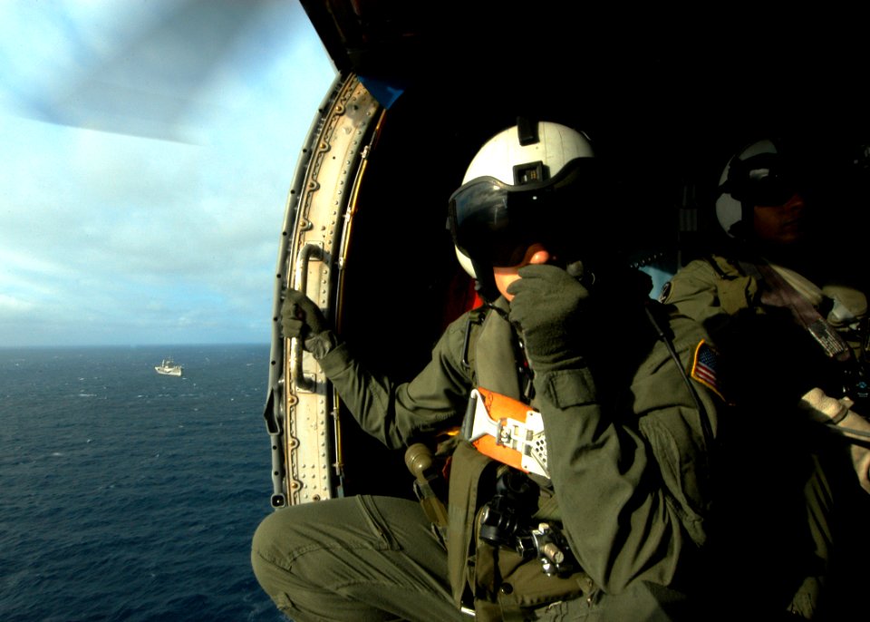 US Navy 060317-N-7526R-075 Aviation Warfare Systems Operator 3rd Class Karl Stiglbauer, assigned to the Warlords of Helicopter Anti-Submarine Squadron Light Five One (HSL-51), communicates with the pilot