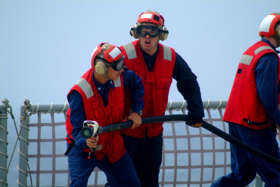 US Navy 060411-N-4772B-036 Electronics Technician 3rd Class Julian Ayala and Hull Maintenance Technician Fireman Michael D. Elliott conduct firefighting efforts during a crash and smash drills