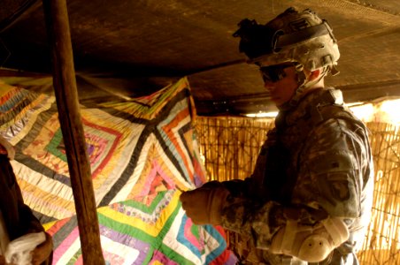 US Navy 060322-N-4614W-043 U.S. Army Pvt. 1st Class Hershey, a medic with 3rd Battalion, 320th Field Artillery Regiment, provides pain-relieving medicine to a local herdsman's family