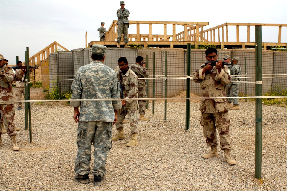 US Navy 060412-N-4614W-005 Army Sgt. Randal Boyd assigned to Headquarters Company, 1st Battalion, 327th Infantry Regiment, observes how Iraq Army soldiers from 5th Battalion, assault a glasshouse during military operations on