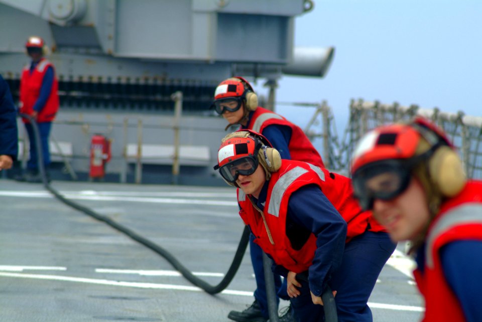 US Navy 060411-N-4772B-040 Hull Maintenance Technician 3rd Class Joel Weiss mans an Aqueous Film Forming Foam (AFFF) hose with other flight deck personnel during a crash and smash drill