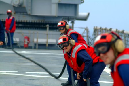 US Navy 060411-N-4772B-040 Hull Maintenance Technician 3rd Class Joel Weiss mans an Aqueous Film Forming Foam (AFFF) hose with other flight deck personnel during a crash and smash drill photo