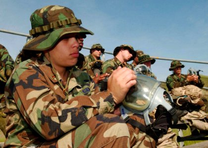 US Navy 060420-F-0692M-068 U.S. Air Force 2nd Lt. Sahira Sanchez assigned to the 30th Space Communications Squadron, corrects her gas mask during the Quick Shot 2006 field exercise