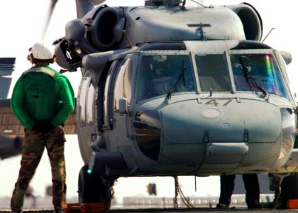 US Navy 060415-N-7359L-001 A Sailor stands in front of an MH-60S Seahawk helicopter assigned to the Nightdippers of Helicopter Anti-Submarine Squadron Five (HS-5)