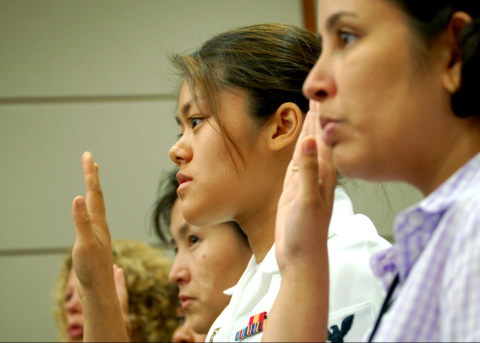 US Navy 060421-N-3855M-001 Aviation Machinist Mate 3rd Class Mony R. En raises her right hand at the Naturalization Ceremony held at the U. S. District Court Middle Florida