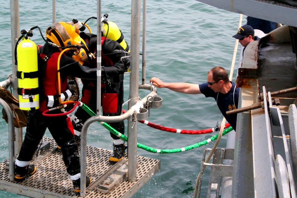 US Navy 060508-F-6344A-002 Senior Chief Navy Diver Clifford Morin aboard rescue and salvage ship USS Safeguard (ARS 50) tends the dive stage as fellow divers are lowered into the Yellow Sea during a major recovery effort