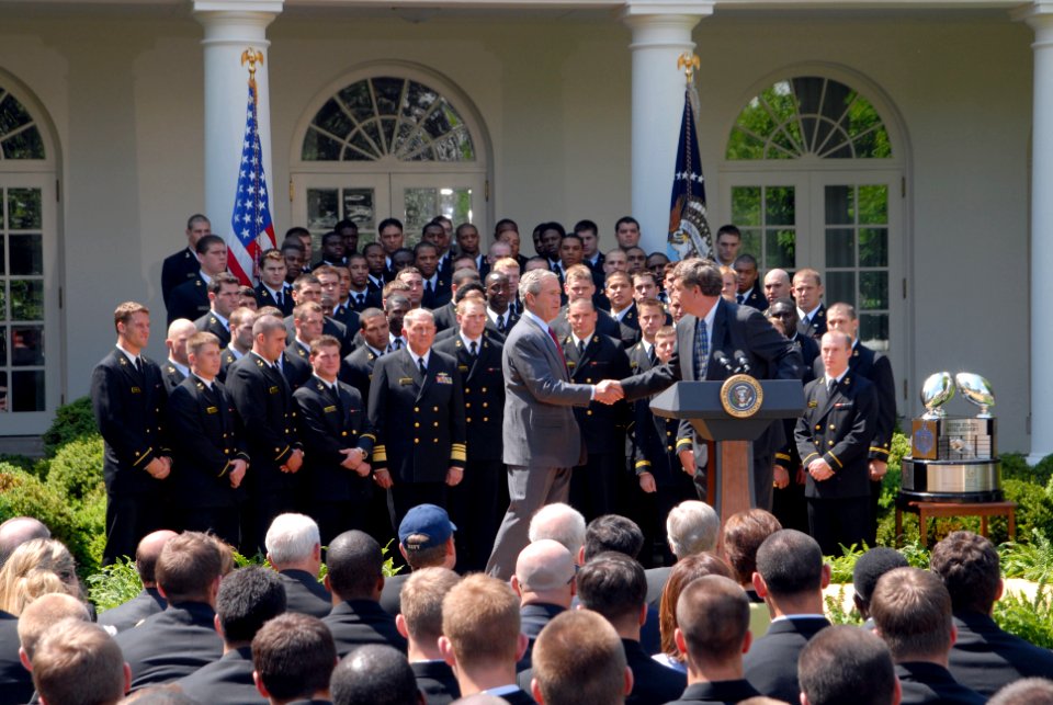 US Navy 060425-N-9909C-007 President George W. Bush shakes hands with the Navy football coach Paul Johnson during the official presentation of the Commander In Chief Trophy to the U.S Naval Academy football team at the White Ho
