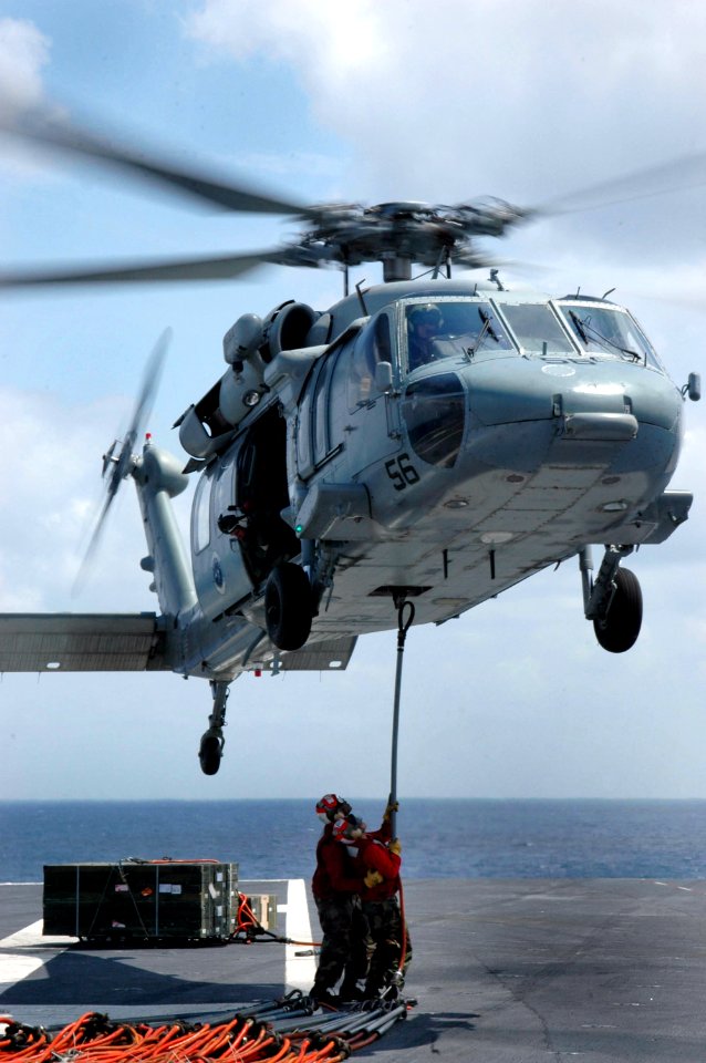 US Navy 060523-N-6106R-196 An MH-60S Seahawk assigned to Helicopter Sea Combat Support Squadron Two Five (HCS-25) prepares to pick up transport cables from the flight deck aboard USS Kitty Hawk (CV 63)