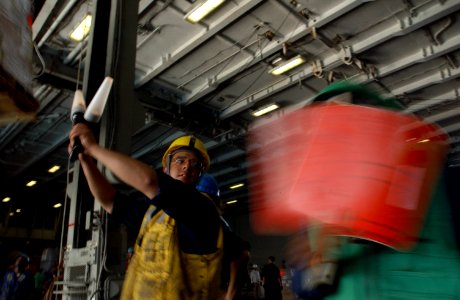 US Navy 060525-N-7526R-034 Boatswain's Mate 3rd Class Michael Gomez gives the stop signal for a cargo load
