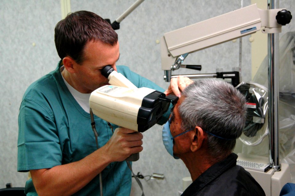 US Navy 060526-N-3532C-045 U.S. Navy Ophthalmologist, Lt. Cmdr. Frank Bishop, M.D., conducts an eye exam for a local resident aboard Military Sealift Command hospital ship USNS Mercy