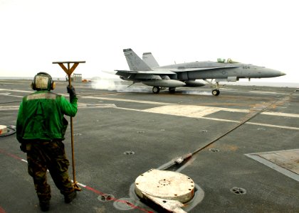 US Navy 060518-N-7981E-039 A member of V-2 Arresting Gears Division stands ready to guide arresting cable back into place as an F-A-18C lands aboard the Nimitz-class aircraft carrier USS Abraham Lincoln (CVN 72)