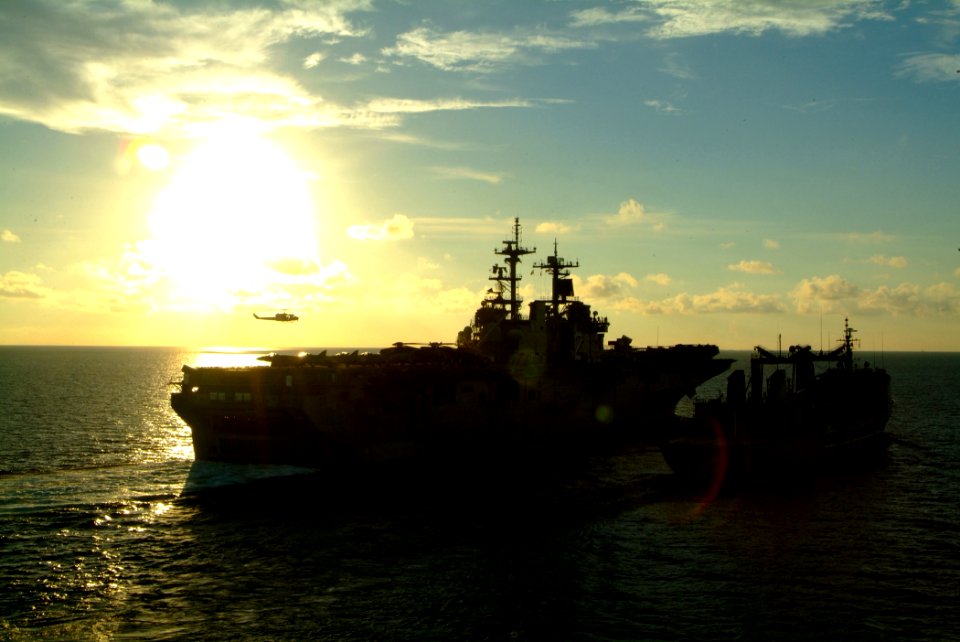 US Navy 060530-N-4772B-066 A helicopter hovers over the flight deck of the amphibious assault ship USS Essex (LHD 2) during an underway replenishment