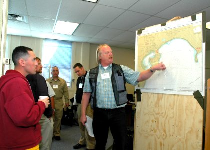 US Navy 060518-N-4385W-007 Operations Section Chief John Noldan gives situational updates using a map of Crescent Harbor