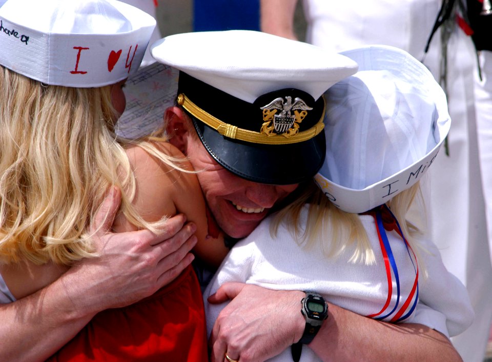 US Navy 060501-N-8033C-139 Lt. Cmdr. Thomas Aydt embraces his daughters upon returning from deployment aboard the Los Angeles-class submarine USS Jefferson City (SSN 759) at Naval Submarine Base Point Loma