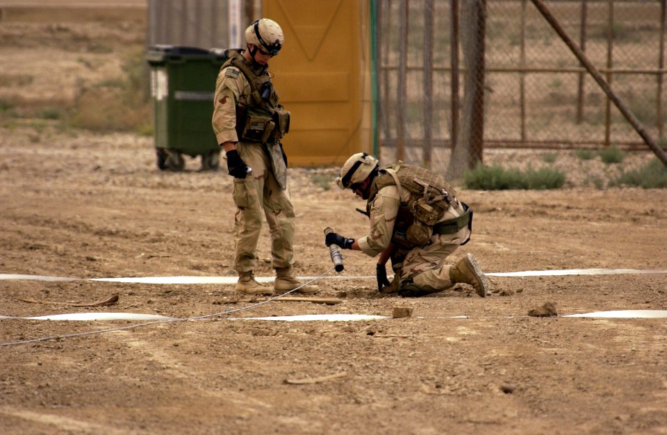 US Navy 060524-F-1424R-029 U.S. Navy Sailors assigned to Disposal Mobile Unit dig up a rocket that landed in Camp Victory, Iraq