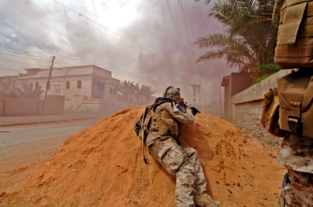 US Navy 060520-N-7497P-307 Links from his ammo belt and brass fly as Sgt. Juan Morales lays down a vicious barrage of gun fire on insurgent positions to cover U.S. Marines movements while on patrol in the city of Ramadi