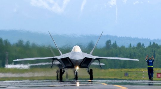 US Navy 060607-F-7049H-002 A crew chief assigned to the 1st Fighter Wing, Langley Air Force Base, Va., directs an F-22A Raptor photo