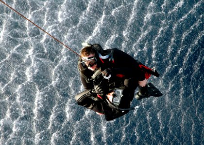 US Navy 060607-N-2651J-062 Air Warfare System's Operator 2nd Class, Randy Eaton pushes himself out of an MH-60S Seahawk helicopter, assigned to Helicopter Sea Combat Support Squadron Twenty Six (HSC-26) Detachment 4, during sea