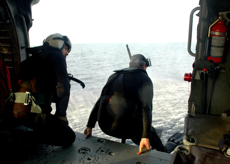 US Navy 060607-N-2651J-022 Air Warfare System's Operator 2nd Class, Randy Eaton pushes himself out of an MH-60S Seahawk helicopter, assigned to Helicopter Sea Combat Support Squadron Twenty Six (HSC-26) Detachment 4