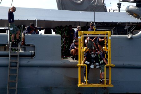 US Navy 060607-N-4205W-006 1st Sgt. Adrian Tay from the Republic of Singapore Navy (RSN) and Machinist's Mate 3rd Class Scott Gee are lowered into the water on the stage from the side of rescue and salvage ship USS Salvor (ARS